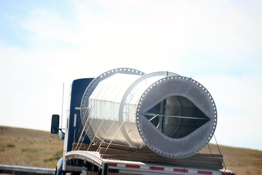 Heavy industrial cargo secured with straps on a flatbed truck for transit